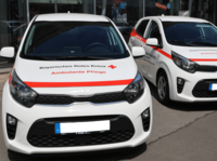 Zwei Fahrzeuge von der BRK Ambulanten Pflege, roter Streifen über die Motorhaube