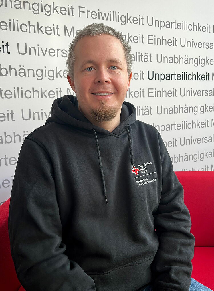 Portrait_Zimmermann_Markus Zeigt Mitarbeitenden mit BRK Oberteil