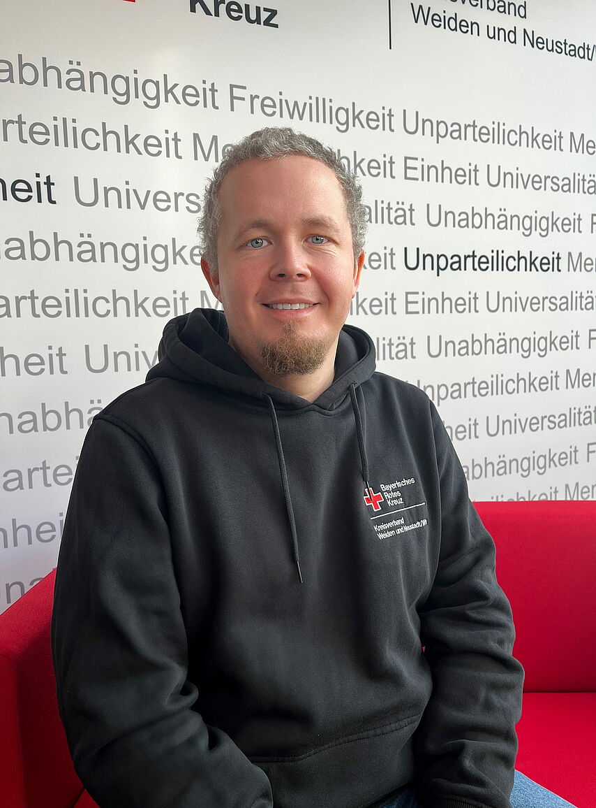 Portrait_Zimmermann_Markus Zeigt Mitarbeitenden mit BRK Oberteil