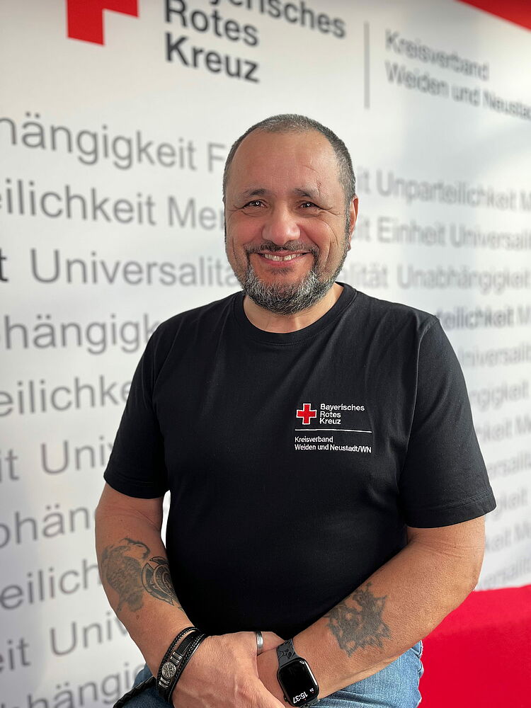 Portrait_Sirtl_Peter Zeigt Mitarbeitenden mit BRK Oberteil